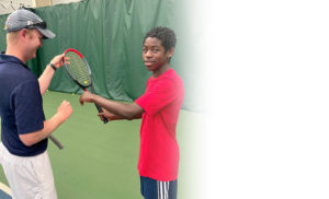 Instructor teaching teen tennis technique